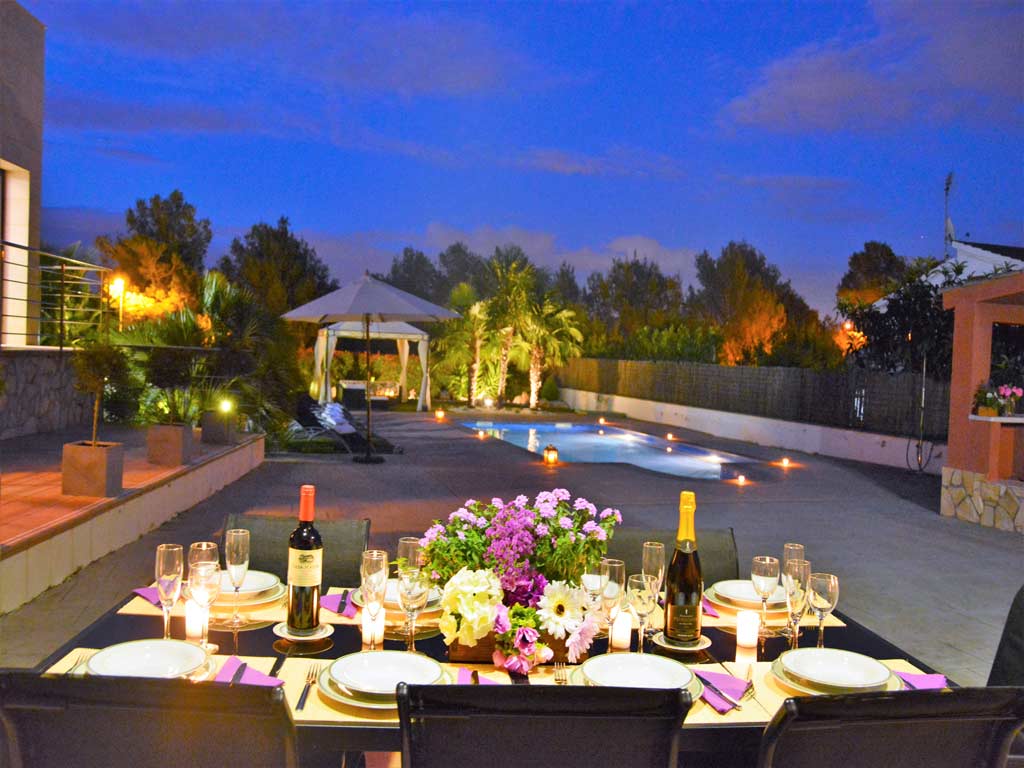 Villa Sitges con comedor exterior de noche.