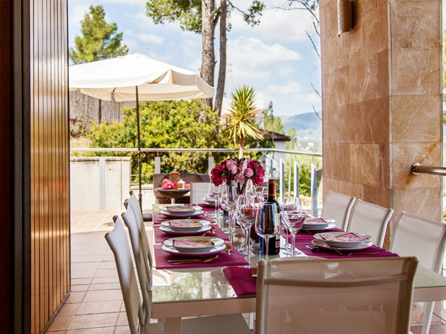 Comedor exterior bajo un techo en el chalet con piscina privada en Sitges